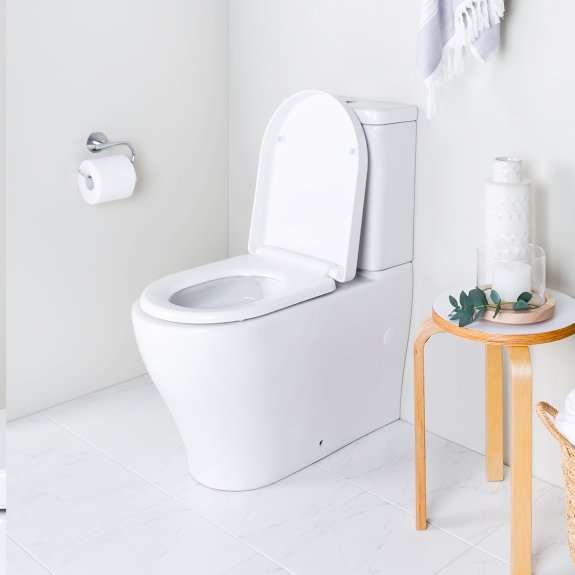 Close-coupled toilet in a white tiled bathroom