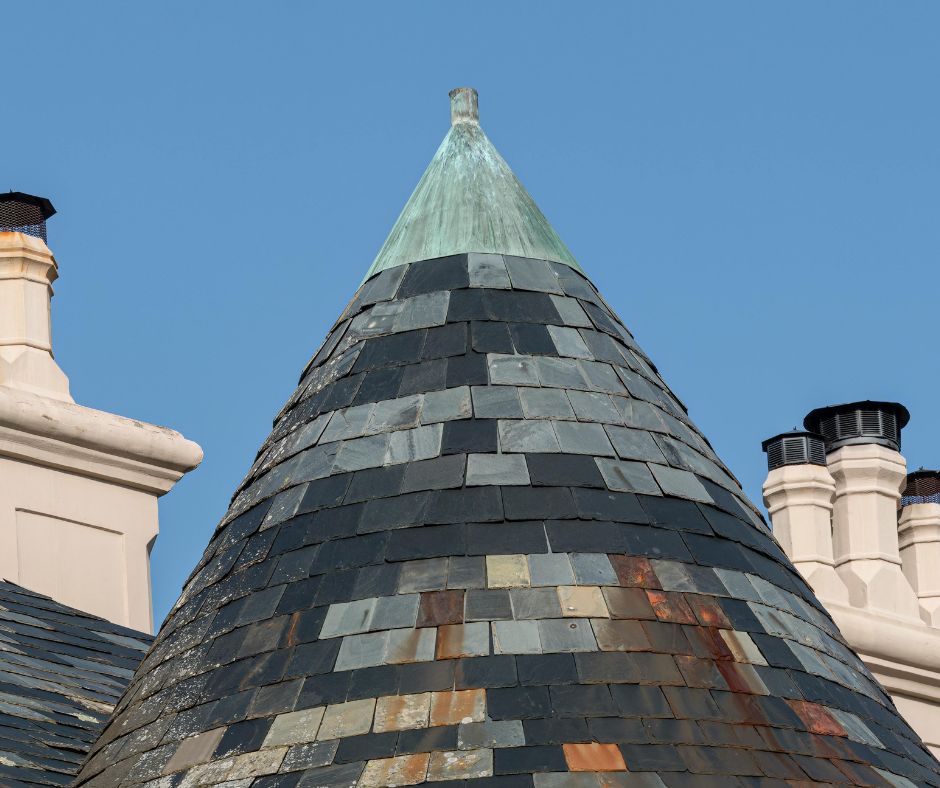 Conical slate turret roof adorned with a copper finial on a heritage building